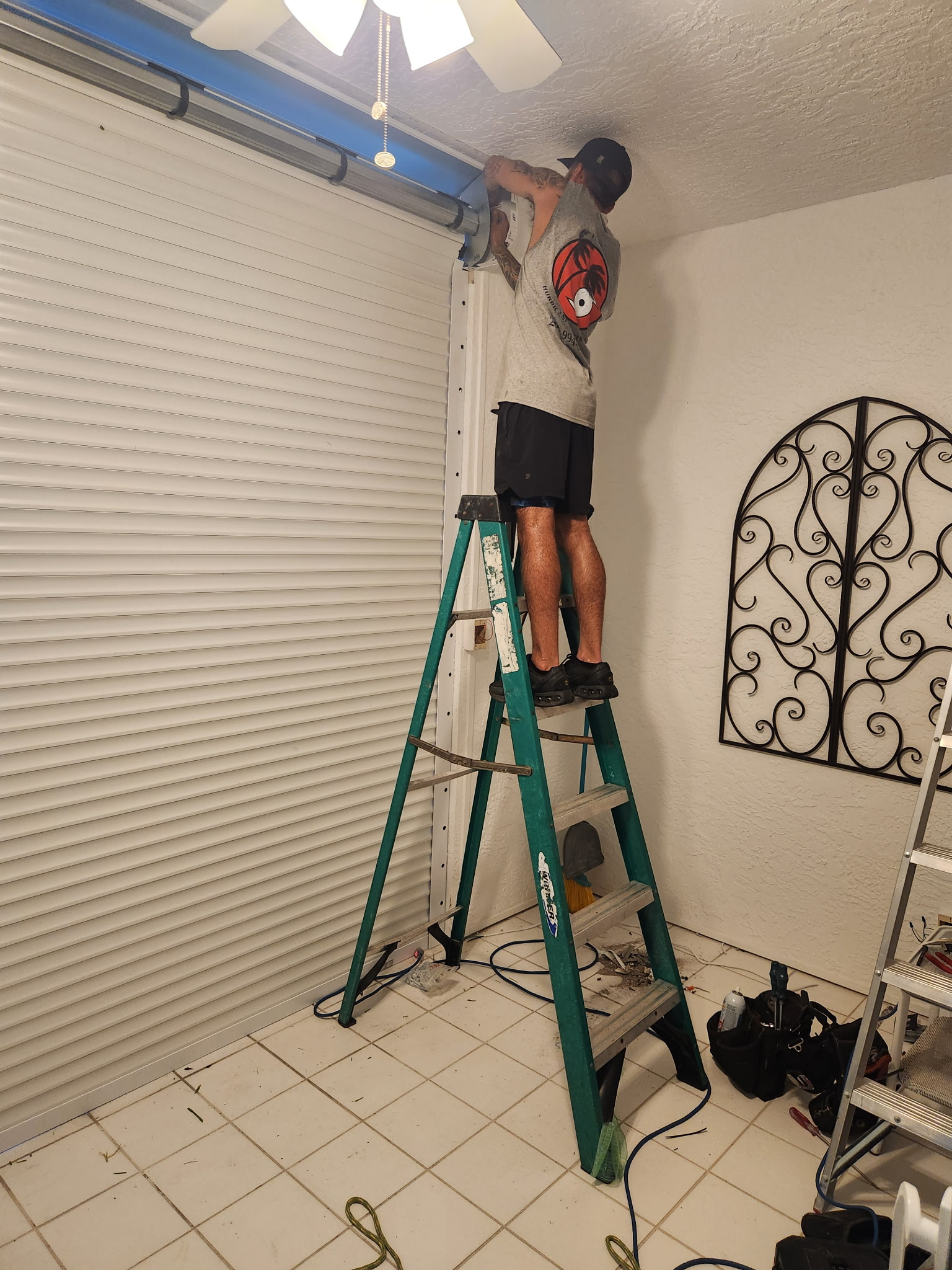 Technician working on a motorized roll-down hurricane shutter